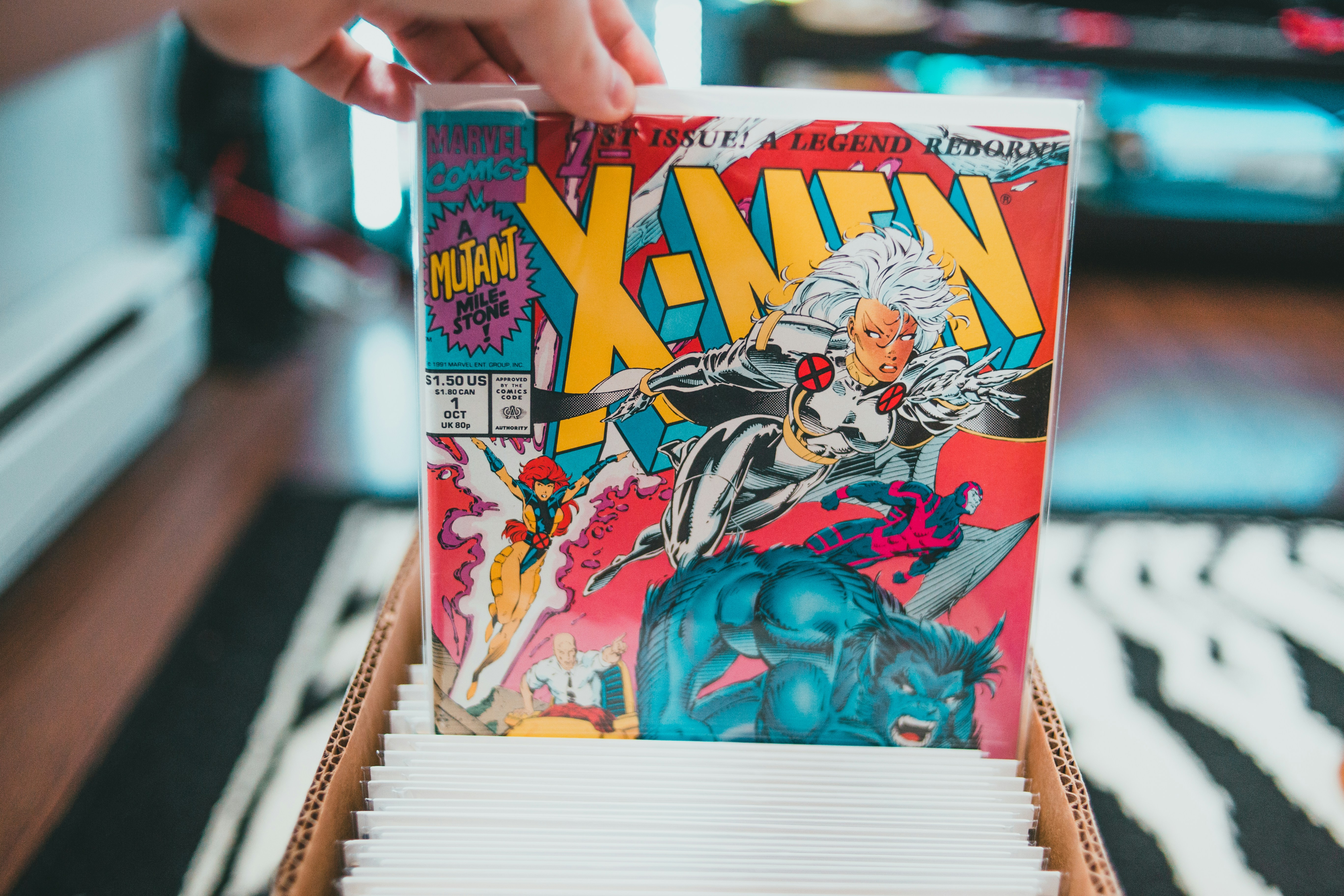 someone picking up a comic from a box